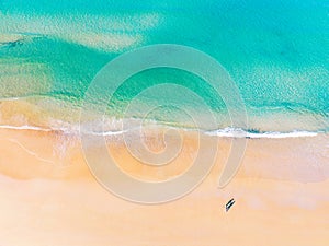 Aerial view of amazing beach with honeymoon couple walking on beach in morning light close to turquoise sea,Top view of summer