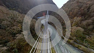 Aerial view amazing nature scenery mountain terrain red sport car driving on cable stayed bridge