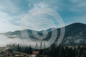 Aerial view amazing over of the Carpathian Mountains or Carpathians with Beautiful autumn landscape , sunrise, blue sky with white