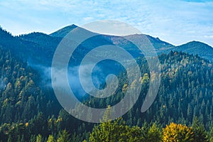Aerial view amazing over of the Carpathian Mountains or Carpathians with Beautiful autumn landscape , sunrise, blue sky with white