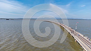 Aerial view of an amazing travel train parked on a floating railway bridge over the water of the lake in Pa Sak Jolasid dam with b