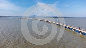 Aerial view of an amazing travel train parked on a floating railway bridge over the water of the lake in Pa Sak Jolasid dam with b