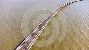 Aerial view of an amazing travel train parked on a floating railway bridge over the water of the lake in Pa Sak Jolasid dam with b