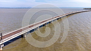 Aerial view of an amazing travel train parked on a floating railway bridge over the water of the lake in Pa Sak Jolasid dam with b