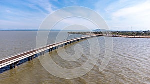 Aerial view of an amazing travel train parked on a floating railway bridge over the water of the lake in Pa Sak Jolasid dam with b