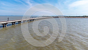 Aerial view of an amazing travel train parked on a floating railway bridge over the water of the lake in Pa Sak Jolasid dam with b