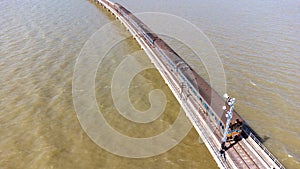 Aerial view of an amazing travel train parked on a floating railway bridge over the water of the lake in Pa Sak Jolasid dam with b