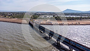 Aerial view of an amazing travel train parked on a floating railway bridge over the water of the lake in Pa Sak Jolasid dam with b