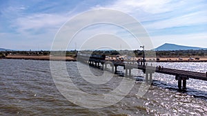 Aerial view of an amazing travel train parked on a floating railway bridge over the water of the lake in Pa Sak Jolasid dam with b