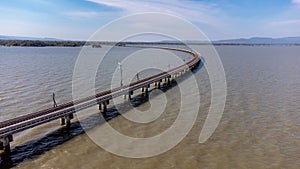 Aerial view of an amazing travel train parked on a floating railway bridge over the water of the lake in Pa Sak Jolasid dam with b