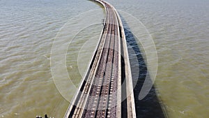 Aerial view of an amazing travel train parked on a floating railway bridge over the water of the lake in Pa Sak Jolasid dam with b