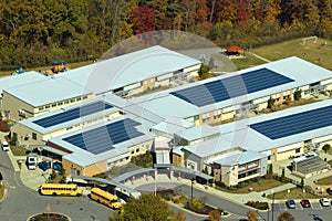 Aerial view of american school building with rooftop covered with photovoltaic solar panels for production of electric