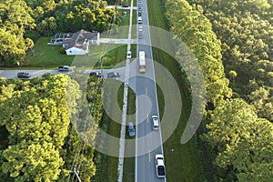 Aerial view of american yellow school bus picking up children at sidewalk bus stop for their lessongs in early morning