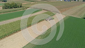 Aerial view of an amish family farm harvesting it's corn crop on a sunny autumn day