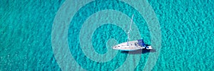 Aerial view of anchored sailing yacht in emerald sea. Aerial view of a boat. Outdoor water sports, yachting. Aerial view of