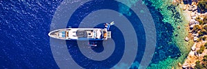 Aerial view of anchored sailing yacht in emerald sea. Aerial view of a boat. Outdoor water sports, yachting. Aerial view of