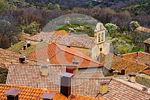 Aerial view of ancient stone town with its red roofs of old tiles and its church tower. La Hiruela Madrid