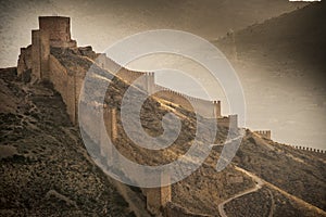 Aerial view of an ancient structure in Aragon, Spain with fog all around it photo