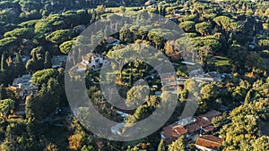Aerial view of ancient Via Appia Antica with green trees, meadows, houses and pathways in Rome, Italy