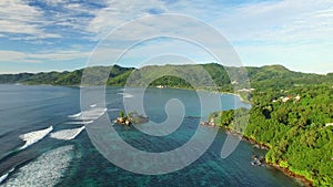 Aerial view of Anse Royale beach with clear sea water of Indian Ocean and green luxuriant hills of Mahe Island, Seychelles, 4k UHD