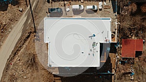 Aerial view of an apartment building with flat roof in construction, ballasted system with geotextile, PVC or EPDM membrane