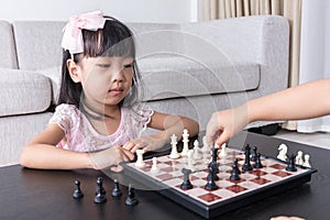 Aerial view of Asian Chinese little girl concentrating on chess