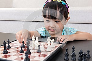 Aerial view of Asian Chinese little girl concentrating on chess