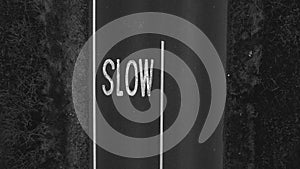 Aerial view of an asphalt road with the word: slow