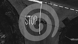 Aerial view of an asphalt road with the word: stop