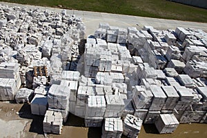 Aerial view of autoclaved aerated concrete blocks, both defective and good, on pallets, stored at factory warehouse