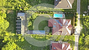 Aerial view of an autonomous house with solar panels on roof and wind generator turbine for producing clean cheap electricity.