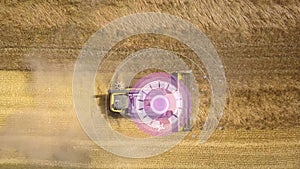 Aerial view of autonomous self-driving combine harvester with autopilot harvesting ripe wheat field using GPS navigation system fo