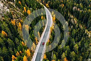 Aerial view of autumn color forest in the mountains and a road with car in Finland Lapland