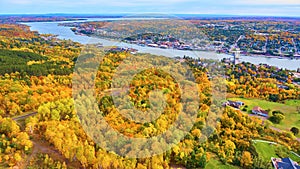 Aerial View of Autumn Forest and Riverside Town with Bridge