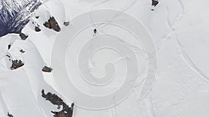 Aerial view of a backcountry skier rides freeride on a steep slope. Professional ski extreme in the mountains of the