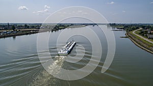 Aerial view:Barge with cargo on the river. River, cargo barge, highway with cars.. Cargo ship on the river