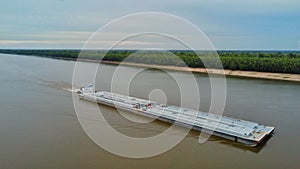 Aerial view of a barge on the Mississippi river with a blue sky in the background