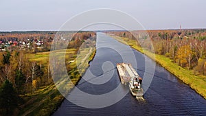 Aerial view:Barge on the river. Autumn landscape, river canal near the forest.