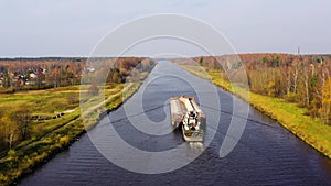 Aerial view:Barge on the river. Autumn landscape, river canal near the forest.