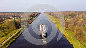 Aerial view:Barge on the river. Autumn landscape, river canal near the forest.