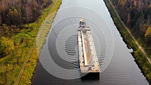 Aerial view:Barge on the river. Autumn landscape, river canal near the forest.