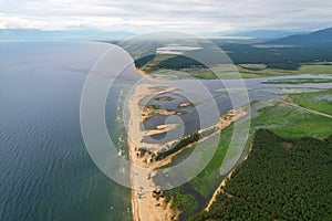 Aerial view of the Barguzin River flowing into Lake Baikal on a cloudy day.