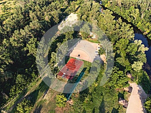 Aerial View of basketball court in a nature environment. Sunset summer day in recreation community part. Drone video of