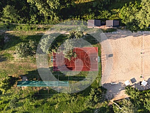 Aerial View of basketball court in a nature environment. Sunset summer day in recreation community part. Drone video of