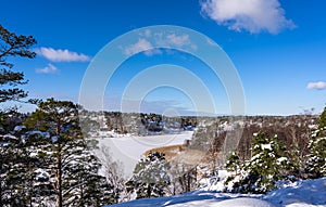 Aerial view of the Bay of the Baltic sea with rocky coasts in winter day. Winter snowy landscape of the Swedish coast on blue sky