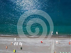 Aerial view of a beach with canoes, boats and umbrellas. Praia a Mare, Province of Cosenza, Calabria, Italy