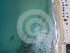 Aerial view of a beach with canoes, boats and umbrellas