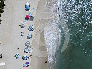 Aerial view of a beach with canoes, boats and umbrellas