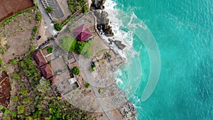 Aerial view beach with rocks and green cliff, top view of a beautiful sandy beach with rocks and waves,