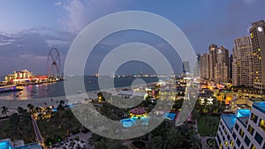 Aerial view of beach and tourists walking in JBR with skyscrapers day to night timelapse in Dubai, UAE